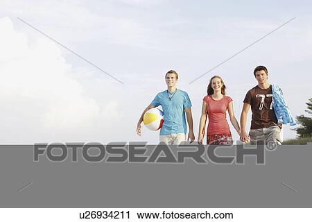 Friends walking on beach View Large Photo Image Stock Image - Friends walking on beach. Fotosearch