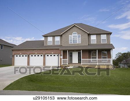 Stock Image - Front view of house with garage. Fotosearch
