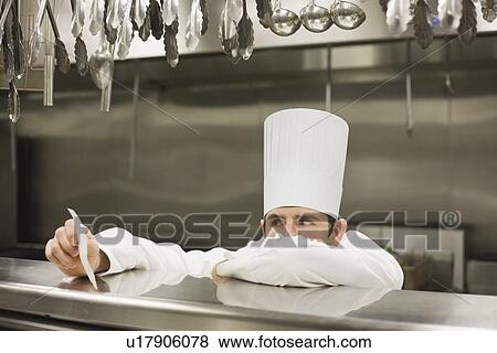 Stock Photo - Frustrated chef reading ticket. Fotosearch