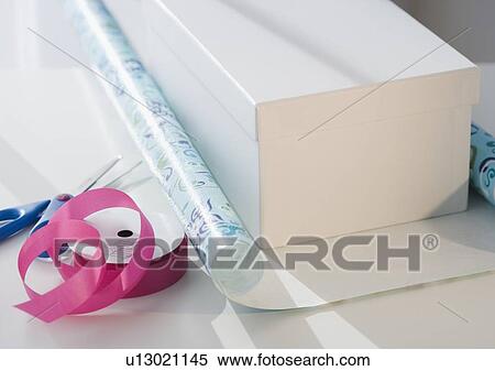 Gift on wrapping paper next to scissors and ribbon View Large Photo Image Stock Photography - Gift on wrapping paper next to scissors and ribbon. Fotosearch