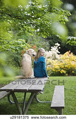 Girl And Dog Sitting On Park Bench Stock Photography U29181375