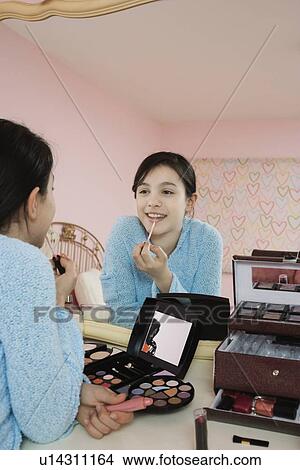 Girl applying lip gloss View Large Photo Image Picture - Girl applying lip gloss. Fotosearch