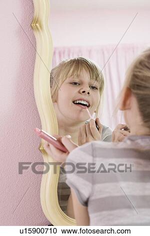 Stock Image - Girl applying lip gloss. Fotosearch