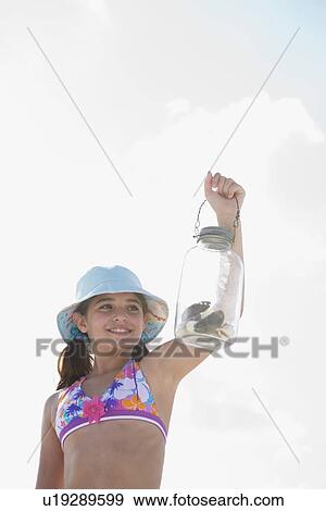 Girl at beach displaying jar of shells View Large Photo Image Stock Photo - Girl at beach displaying jar of shells. Fotosearch