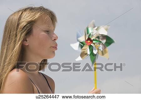 Stock Photo - Girl blowing on pinwheel. Fotosearch