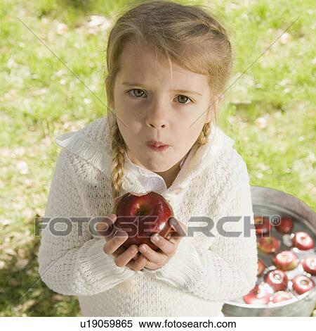 Stock Photography - Girl bobbing for apples. Fotosearch