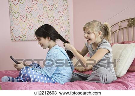 Girl braiding friend’s hair View Large Photo Image Stock Image - Girl braiding friend’s hair. Fotosearch