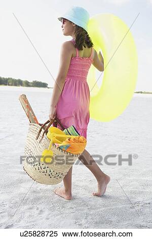 Stock Photography - Girl carrying beach essentials. Fotosearch