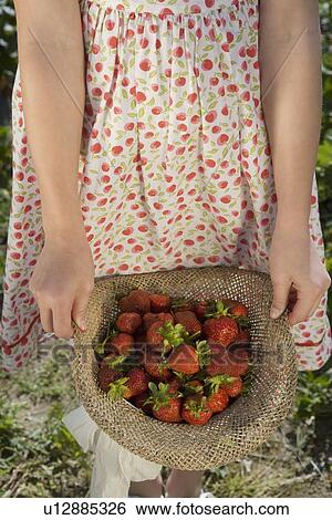 Girl carrying strawberries in straw hat View Large Photo Image Stock Photograph - Girl carrying strawberries in straw hat. Fotosearch