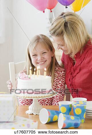 Stock Photography - Girl celebrating birthday with mother. Fotosearch