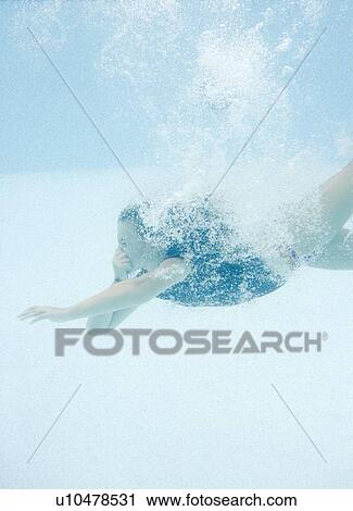 Stock Image - Girl diving underwater. Fotosearch
