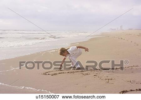 Girl drawing in sand View Large Photo Image Stock Photo - Girl drawing in sand. Fotosearch