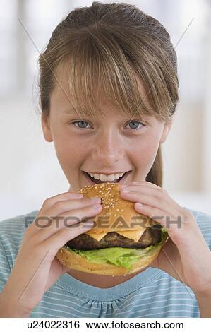 Girl eating hamburger View Large Photo Image Stock Photograph - Girl eating hamburger. Fotosearch