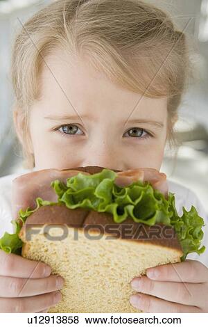 Stock Photo - Girl eating sandwich. Fotosearch