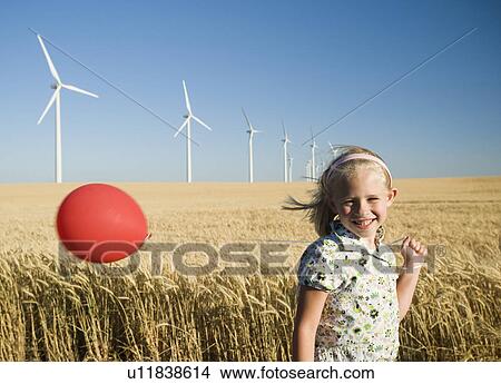 Picture - Girl holding balloon on wind farm. Fotosearch