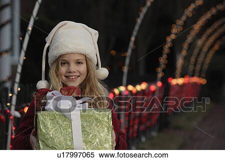 Stock Photography - Girl holding Christmas gift. Fotosearch
