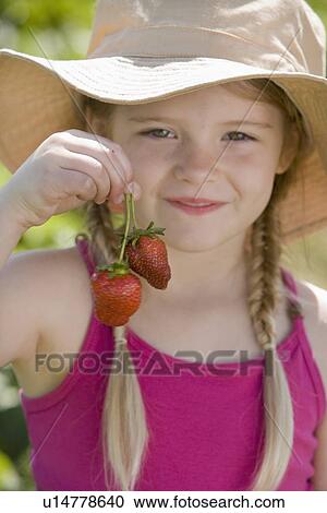Stock Image - Girl holding fresh strawberries. Fotosearch