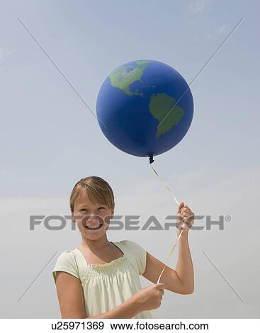 Stock Photo - Girl holding globe balloon. Fotosearch