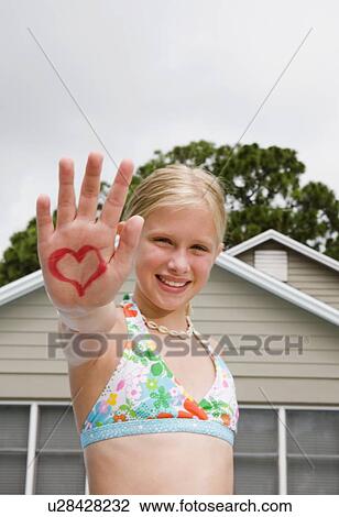 Stock Image - Girl holding out hand painted with heart design. Fotosearch