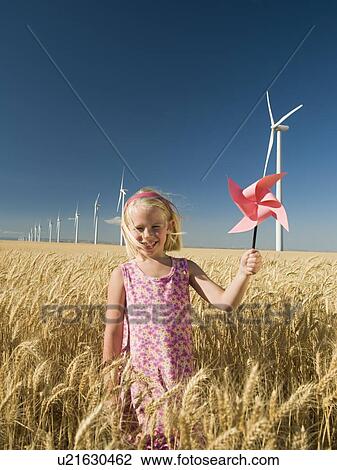 Girl holding pinwheel on wind farm View Large Photo Image Stock Image - Girl holding pinwheel on wind farm. Fotosearch