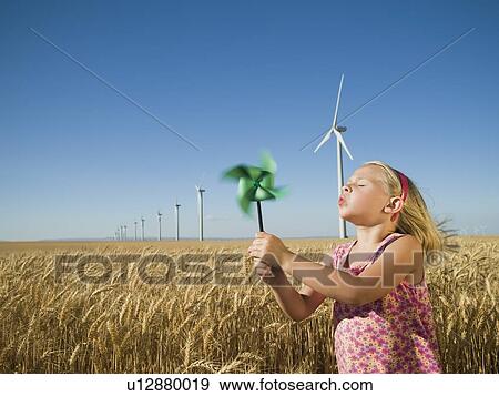 Girl holding pinwheel on wind farm View Large Photo Image Stock Photo - Girl holding pinwheel on wind farm. Fotosearch