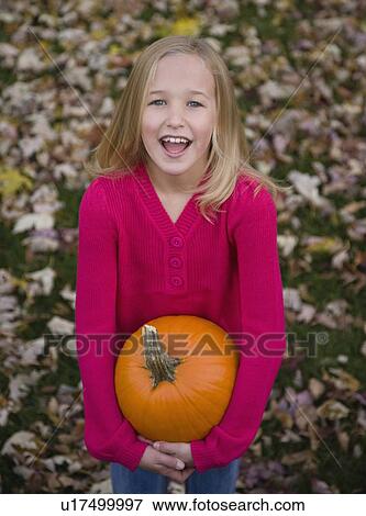 Stock Photo - Girl holding pumpkin. Fotosearch
