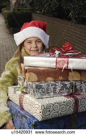 Girl holding stack of Christmas gifts View Large Photo Image Stock Image - Girl holding stack of Christmas gifts. Fotosearch