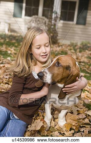 Stock Photograph - Girl hugging dog outdoors. Fotosearch