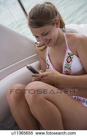 Girl in bikini dialing cell phone View Large Photo Image Stock Photography - Girl in bikini dialing cell phone. Fotosearch