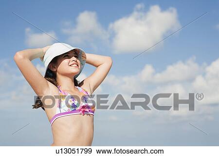 Stock Photo - Girl in bikini looking into sunny sky. Fotosearch