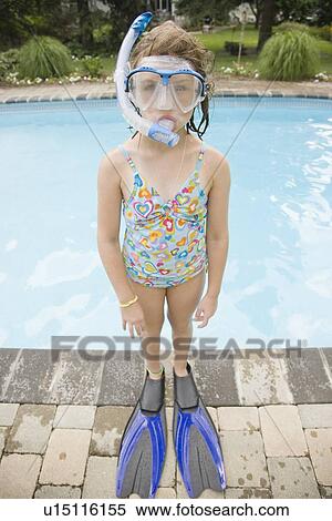 Stock Photography - Girl in snorkeling gear standing at edge of swimming pool. Fotosearch