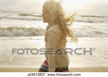 Stock Photo - Girl in sunlight at beach. Fotosearch