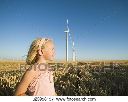 Girl in tall wheat field on wind farm View Large Photo Image Stock Photo - Girl in tall wheat field on wind farm. Fotosearch