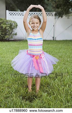 Girl in tutu posing on lawn View Large Photo Image Stock Image - Girl in tutu posing on lawn. Fotosearch