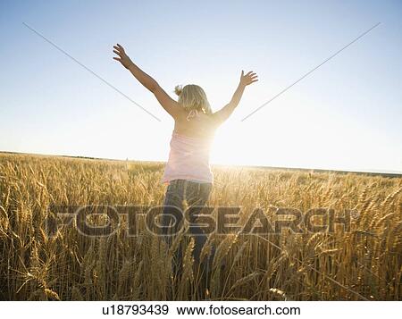 Stock Photo - Girl jumping in tall wheat field. Fotosearch