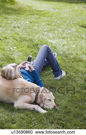 Girl leaning on dog in park View Large Photo Image Stock Image - Girl leaning on dog in park. Fotosearch