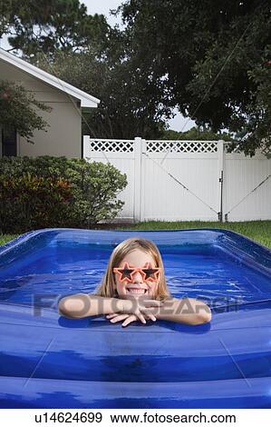 Girl leaning on edge of inflatable swimming pool View Large Photo Image Stock Photo - Girl leaning on edge of inflatable swimming pool. Fotosearch