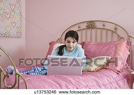 Stock Photograph - Girl looking at laptop. Fotosearch