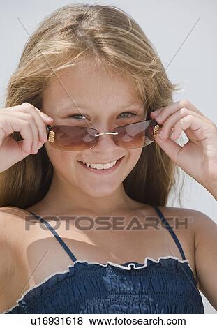 Girl looking over sunglasses View Large Photo Image Stock Photo - Girl looking over sunglasses. Fotosearch