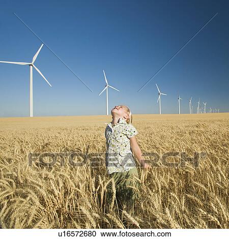 Girl looking to sky on wind farm View Large Photo Image Stock Image - Girl looking to sky on wind farm. Fotosearch
