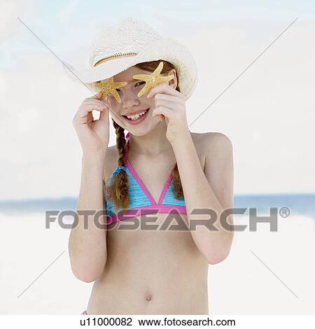 Girl on beach holding starfish View Large Photo Image Stock Image - Girl on beach holding starfish. Fotosearch