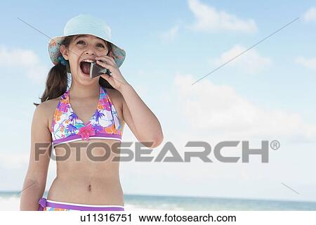Girl on beach talking on cell phone View Large Photo Image Stock Image - Girl on beach talking on cell phone. Fotosearch