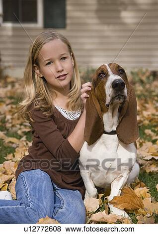 Stock Photo - Girl petting dog outdoors. Fotosearch