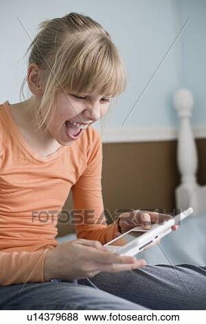 Girl playing handheld video game View Large Photo Image Stock Photo - Girl playing handheld video game. Fotosearch