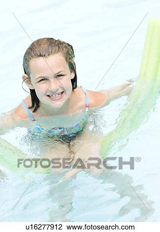 Girl playing on inflatable raft in swimming pool View Large Photo Image Stock Image - Girl playing on inflatable raft in swimming pool. Fotosearch