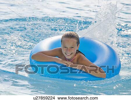 Girl playing with inflatable tube in swimming pool View Large Photo Image Picture - Girl playing with inflatable tube in swimming pool. Fotosearch