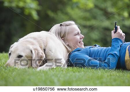 Girl resting on dog in park View Large Photo Image Stock Photograph - Girl resting on dog in park. Fotosearch