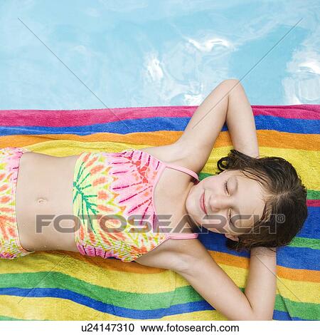 Girl resting on towel at edge of swimming pool View Large Photo Image Stock Image - Girl resting on towel at edge of swimming pool. Fotosearch