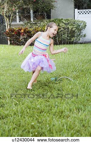 Girl running through sprinkler View Large Photo Image Picture - Girl running through sprinkler. Fotosearch