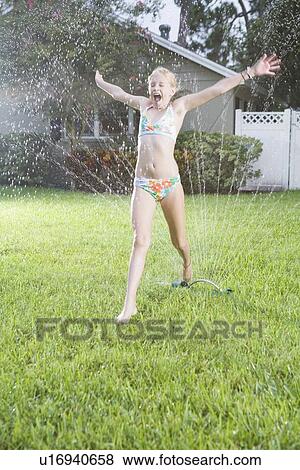 Girl running through sprinklers View Large Photo Image Stock Photo - Girl running through sprinklers. Fotosearch